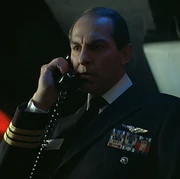 A commander in the 20th century United States Navy, wearing the sleeve insignia for the rank as well as several military decorations.