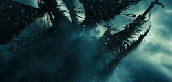 The Flying Dutchman bursts from the ocean depths.
