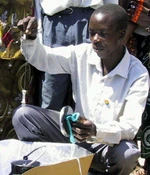 Meatu resident Boniphace Luhende demonstrates solar water pasteurization using a CooKit and WAPI