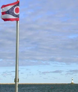 Ohio state flag in Conneaut, Ohio with lighthouse in the background.