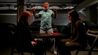 Scully and Reyes play checkers as their strange companion dances